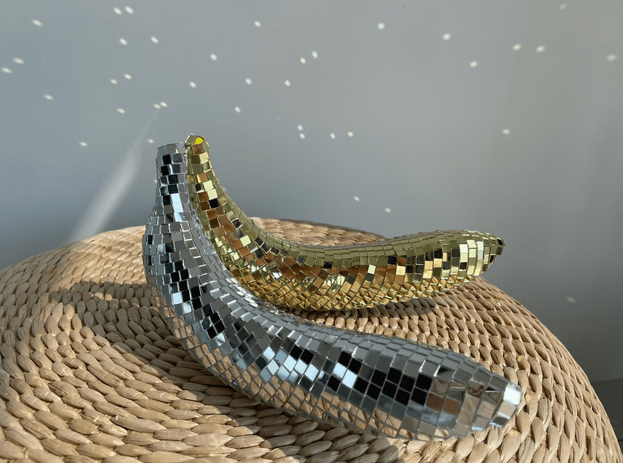 Reflective silver and gold disco banana decorations on a woven surface, creating a dazzling art piece for home decor.